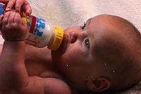 Fotografía de un bebé comer solo una botella Fotografía de un bebé comer solo una botella