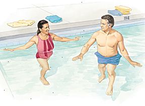 Hombre y mujer que camina en parte menos profunda de la piscina.