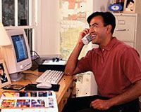 Imagen de un hombre trabajando en la computadora, hablar por teléfono Imagen de un hombre trabajando en la computadora, hablar por teléfono