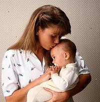 Fotografía de una madre besando a su bebé en la frente Fotografía de una madre besando a su bebé en la frente