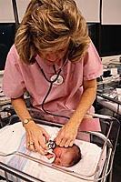 Fotografía de un médico escuchando a un recién nacido